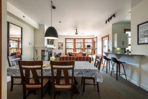 uma cozinha e sala de estar com mesa e cadeiras em Le Serein Condo 1 chambre à Tremblant Les-Eaux em Mont-Tremblant