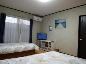 - une chambre avec 2 lits et une télévision à écran plat dans l'établissement Bibi Vacation Rental Only 2 groups per day Vacation STAY 1284, à Sakai