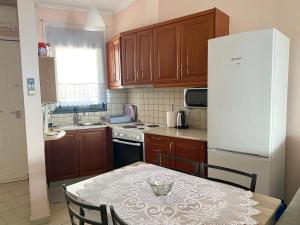 a kitchen with a table and a white refrigerator at Villa Porto Thassos in Limenas