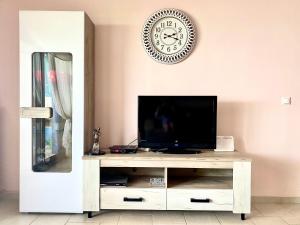a living room with a tv and a clock on the wall at Villa Porto Thassos in Limenas