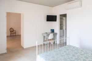 a white bedroom with a bed and a desk at FONTE D'OLIO CONERO RELAIS in Sirolo