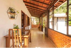 a porch of a house with a table and chairs at Hotel Boutique Pé Da Tartaruga in Teresópolis