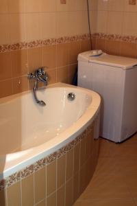 een badkamer met een bad, een toilet en een wastafel bij Tó apartman in Tihany