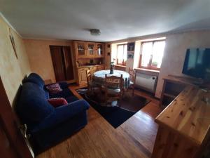 ein Wohnzimmer mit einem blauen Sofa und einem Tisch in der Unterkunft CA DUL DALU in Baceno