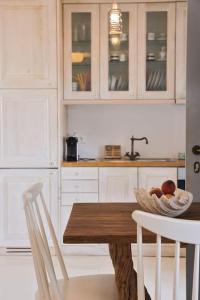 a kitchen with a wooden table and white cabinets at Amelia Private Pool Apartment in Panormos Mykonos