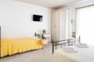 a bedroom with two beds and a tv at FONTE D'OLIO CONERO RELAIS in Sirolo
