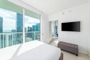Un dormitorio blanco con una cama grande y una ventana grande. en 4BR Penthouse with Oceanview at Brickell, Free Parking, en Miami