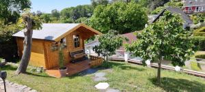 a wooden cabin with a deck in a yard at Apartment Tintenfisch Strandkorb inkl in Göhren