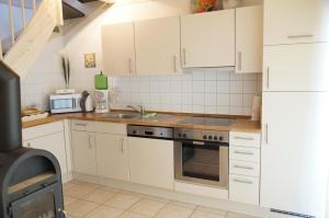 a kitchen with white cabinets and a stove at Strandpark Sierksdorf H073 in Sierksdorf