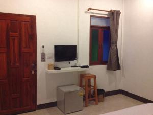 a room with a tv and a window and a door at Space Ben Guest House @ Muangkao in Sukhothai