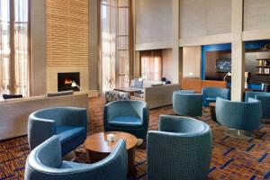 a lobby with blue chairs and a fireplace at Sonesta Select Las Vegas Summerlin in Las Vegas