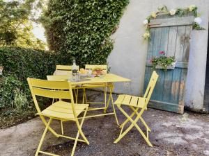een gele tafel en stoelen naast een gebouw bij Lemonade Cottages and Retreat in Kilrush