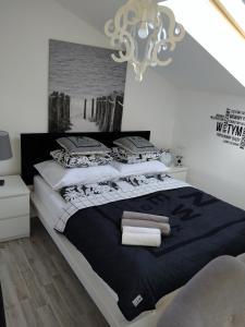 a bedroom with a black and white bed and a chandelier at Willa La mer in Ustka