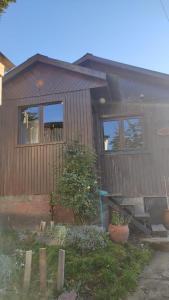 a house with a fence and some plants in front of it at Cabaña del Antiguo Poblador in Ushuaia +4 photos
