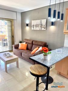 a living room with a couch and a table at APARTBEACH TURQUESA BJ CLIMATIZADO JUNTO PLAYA y PISCINAS in La Pineda