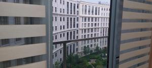 a view of a tall white building from a window at 81 Newport,NAIA 3,Pasay Condotel in Manila