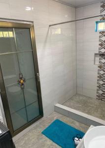 a bathroom with a shower and a blue rug at Carnbee Cozy Cottage in Bethel