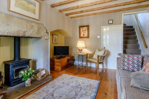 a living room with a fireplace and a tv at Snowdrop Cottage in Wetherby