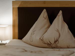 a bed with a pillow with a deer on it at Chalet Windbach in Saalbach-Hinterglemm