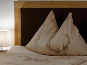 a bed with a pillow with a deer on it at Chalet Windbach in Saalbach Hinterglemm