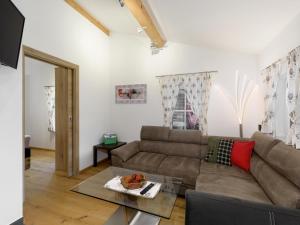 a living room with a couch and a table at Chalet Windbach in Saalbach-Hinterglemm