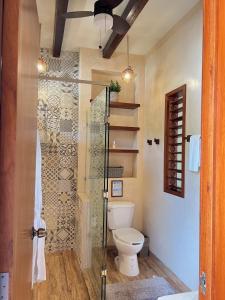 La salle de bains est pourvue de toilettes et d'une douche en verre. dans l'établissement Villa Marcela, à Calderitas
