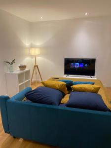 un divano blu con cuscini in soggiorno di Lorient: appartement élégant a Lorient