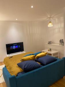 un sofá azul con almohadas amarillas en la sala de estar. en Lorient: appartement élégant en Lorient