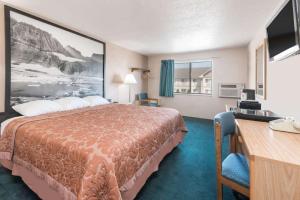 Habitación de hotel con cama y escritorio en Glendive Lodge, en Glendive