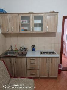 een keuken met houten kasten en een wastafel bij Sutomore apartments Anika in Sutomore