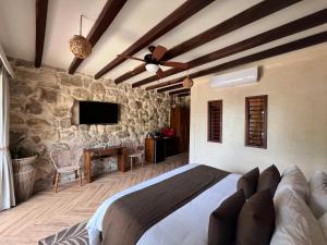 a bedroom with a bed and a stone wall at Villa Marcela in Calderitas