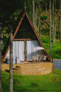 uma cabina de madeira com uma mesa e um guarda-chuva em Cabanas do avencal em Urubici