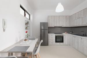 uma cozinha com armários de madeira e uma mesa com cadeiras em Rooftop Cosy Apartment Perfect Location em Heraclião