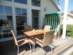 einen Holztisch und Stühle auf einer Terrasse in der Unterkunft Strandpark Sierksdorf H052 in Sierksdorf