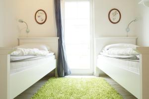 2 Betten in einem Schlafzimmer mit grünem Teppich in der Unterkunft Strandpark Sierksdorf H052 in Sierksdorf