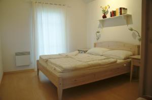 - une chambre avec un lit en bois devant une fenêtre dans l'établissement Strandpark Sierksdorf H057, à Sierksdorf