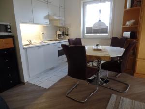 eine Küche mit einem Tisch und Stühlen im Zimmer in der Unterkunft Objekte im Umland Neuklosterhof App 10 in Pelzerhaken