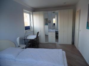 ein Schlafzimmer mit einem Bett, einem Schreibtisch und einem Entskablish in der Unterkunft Objekte im Umland Neuklosterhof App 10 in Pelzerhaken