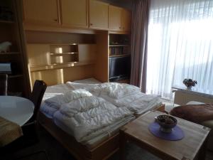 Schlafzimmer mit einem Bett, einem Tisch und einem Fenster in der Unterkunft Objekte im Umland Neuklosterhof App 10 in Pelzerhaken