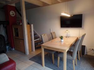 a dining room with a wooden table and chairs at Strandpark Sierksdorf H010 in Sierksdorf