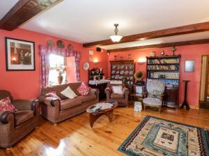 a living room with orange walls and furniture at An Maide Bán in Cootehill