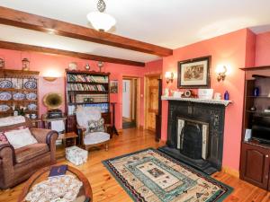 a living room with pink walls and a fireplace at An Maide Bán in Cootehill