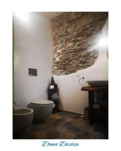 een badkamer met een toilet en een stenen muur bij Domo Dizósa in Siniscola