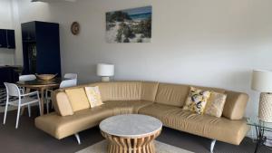 a living room with a couch and a table at Unit 10 Sea Eagles Apartments in Caloundra