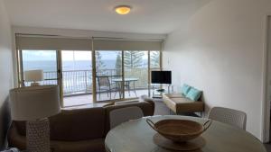 a living room with a couch and a table at Unit 10 Sea Eagles Apartments in Caloundra