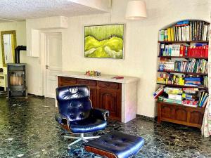 a room with a chair and a book shelf with books at Majestic villa in Lecci with garden in Lecci