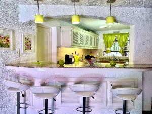 a kitchen with a counter with stools around it at Majestic villa in Lecci with garden in Lecci