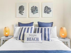 a bedroom with a bed with blue and white pillows at Serene Beachside Apartment in Marcoola