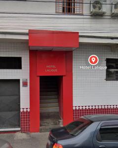 ein roter Eingang zu einem Hotelgebäude mit einem draußen geparkt in der Unterkunft Hotel Lalique in São Paulo