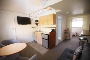 a kitchen and a living room with a table at Tuross Head Motel in Tuross Heads
